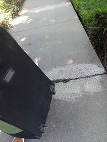 My broken luggage. Notice those black lines on the pavement which were left by its broken wheels.