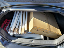 Table, legs, and a chair nicely packed in a car trunk.